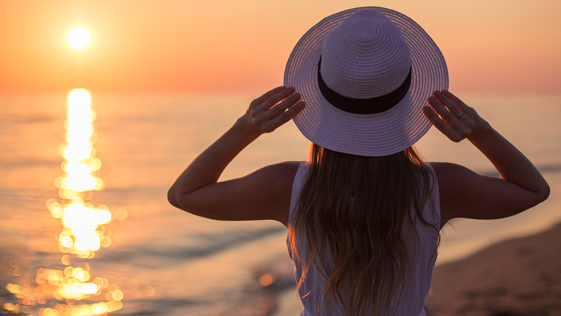 A woman on the beach watching the sunset