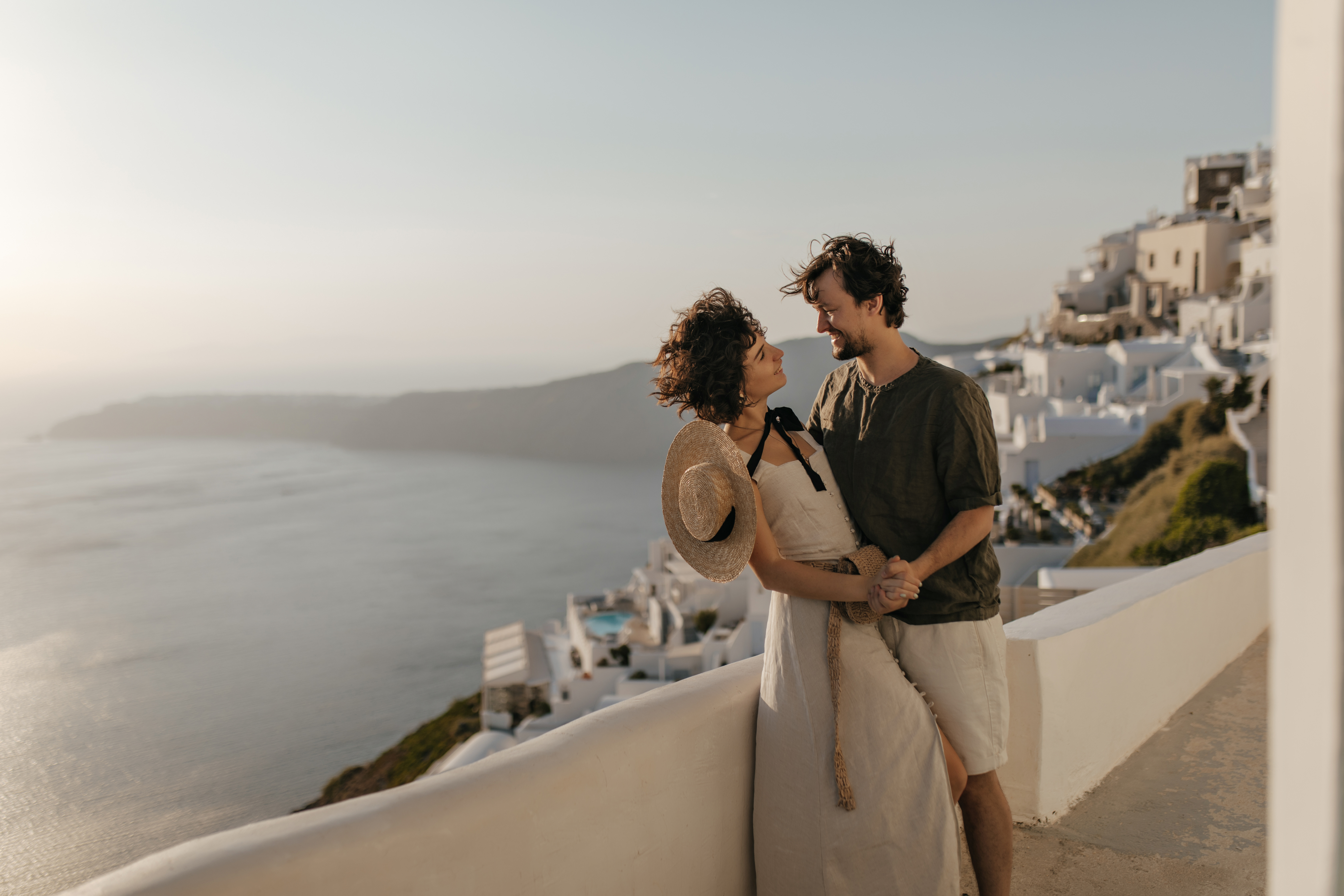 attractive-woman-beige-dress-boater-brunette-man-hold-hands-look-each-other-with-love-couple-poses-beautiful-romantic-place-with-sea-view.jpg
